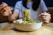 Best UK supermarket pesto named over M&S, Aldi, Asda, Tesco, Lidl and Morrisons Woman Eating Green Pesto Pasta with Forks at Restaurant Table