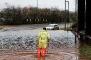 Workers assess the situation where two cars were abandoned in flood water near Fenny Bridges on January 27, 2026 in Otter Saint Mary, England