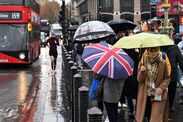 LONDON, ENGLAND - NOVEMBER 10: People shelter from the rain under umbrellas in Westminster on November 10, 2025 in London, England