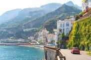 Red car drives on a scenic Amalfi Coast