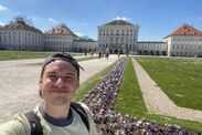 Man takes a selfie in front of a German palace on a sunny day