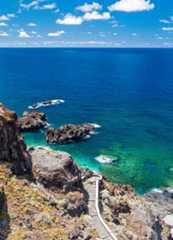 Stock photo of a volcanic rock rim landscape with turquoise blue sea. A walk down to the sea. El Hierro, Canary Island.