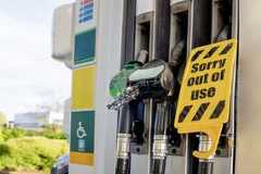 Fuel pump displays out of service sign at a gas station in an urban area during bright daylight hours