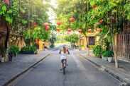Woman visiting the old city of Hoi An in Vietnam by bike during morning