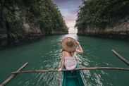 Woman exploring a river on small boat at sunset, Philippines