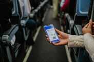 A woman shows her air ticket on a phone
