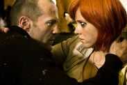 An individual with a bald head and another person with red hair are engaged in a close, intense interaction, possibly depicting 