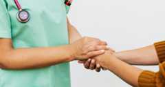 Nurse holding a patients hands