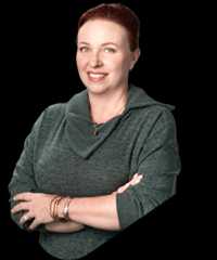 Amy howells triangle foreground min 2 Amy howells smiling in a green sweater with bracelets.