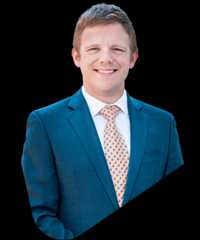 David warren triangle foreground min David warren in a blue suit, white shirt, and patterned tie.