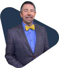 Sean elliot, educator, smiling in a gray blazer and blue shirt.