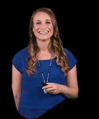 Paula ruedebusch smiling in a blue top holding a remote.