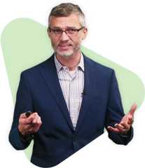 Stephen hold, wearing glasses and a blazer, presents on a green background.