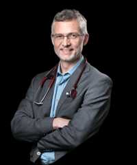 Professional man in suit, glasses, stethoscope, smiling.