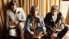 Rock musicians (from left to right) Greg Lake (1947 - 2016), Keith Emerson (1944 - 2016), and Carl Palmer, of the group Emerson Lake And Palmer receive their awards at the 1972 Melody Maker Pop Poll; readers of the weekly music paper voted ELP the World's Top Group, and between then they won seven awards, 30th September 1972. (Photo by Michael Putland/Getty Images)