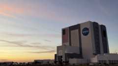 A building with the NASA logo. There is a sunset and pinkish clouds.