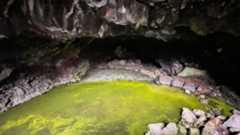 Interior of the Bandera Volcano Ice Cave in New Mexico. The cave's floor is covered in ice which itself is covered in a carpet of algae.