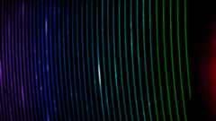 A series of brightly coloring curved colored lines creating strips of rainbow over a dark black background