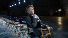 Robert Downey Jr sitting in a chair and holding a finger to his lips during Marvel's Avengers: Doomsday cast reveal