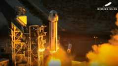 a white rocket topped by a gumdrop-shape capsule launches