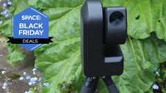 A zwo seestar s50 smart telescope in front of leaves in a garden. 