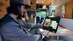 Dell Plus Laptop 2-in-1 in stand mode on a desk, being used by a person