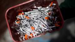 A bucket of needles is seen outside a health clinic in Portland, Maine. 