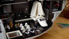 The interior of a circular space station with several floors and rooms filled with minifigures shows the minifigures posed in action.