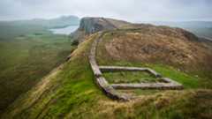 a series of small walls in a lush, mountainous landscape