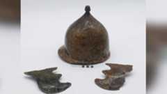 a bronze conical helmet flanked by two cheek pieces