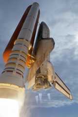 The space shuttle Discovery roars between the clouds into the blue Florida sky toward space on mission STS-120 to the International Space Station on Oct. 23, 2007.