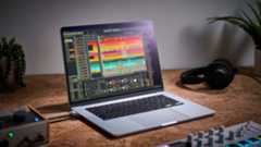 An Apple MacBook Air M4 on a desk with audio interface, headphones, and MIDI controller