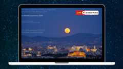 a graphic of a laptop with the view of the full moon livestream on the screen with text saying live streaming in the top right corner and a background of stars behind the laptop.