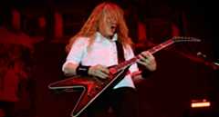 Dave Mustaine wears a white shirt and plays his signature Gibson as he performs with Megadeth in 2025.