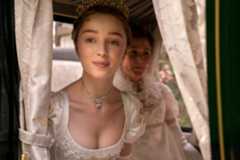 Phoebe Dynevor as Daphne Bridgerton, looks out from inside a carriage in Bridgerton
