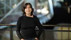 AU 2025; a woman stands in front of a metal railing