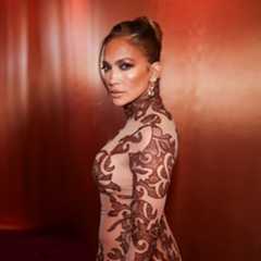 a woman with honey blonde hair posing in front of an orange background