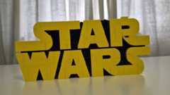 The Star Wars logo, which is the word &quot;Star&quot; above the word &quot;Wars&quot;, in yellow lettering on a black background, in Lego form. 