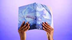 Two hands hold aloft a new book from Folio. 