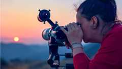 Woman using a solar telescope to look at the sun safely