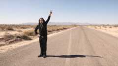 Ozzy Osbourne standing on a desert road