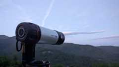 a black and white telescope in a field