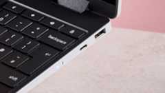 Close-up of right side ports on Samsung Galaxy Chromebook 2 360, open on desk with pink background