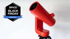 The Unistellar Odyssey Pro smart telescope in red on a white background with a Space.com Black Friday deals badge in black and blue.