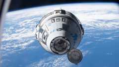 A white and blue Boeing Starliner capsule floats above a blue Earth with the black of space in the background.