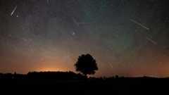 A photograph of a meteor shower in the night sky.
