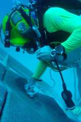 NEEMO diver anchoring on a simulated asteroid surface.