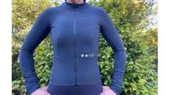 Universal Colours Mono Long Sleeve Jersey in blue shown close up on a white woman in front of a green bush