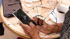 A phone with a cracked screen overlaid with a crack on the image