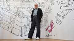 Quentin Blake in front of his illustrations